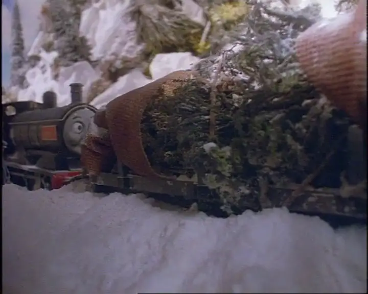 クリスマスツリーを乗せた積載貨車を後ろ向きで牽引しているドナルド
